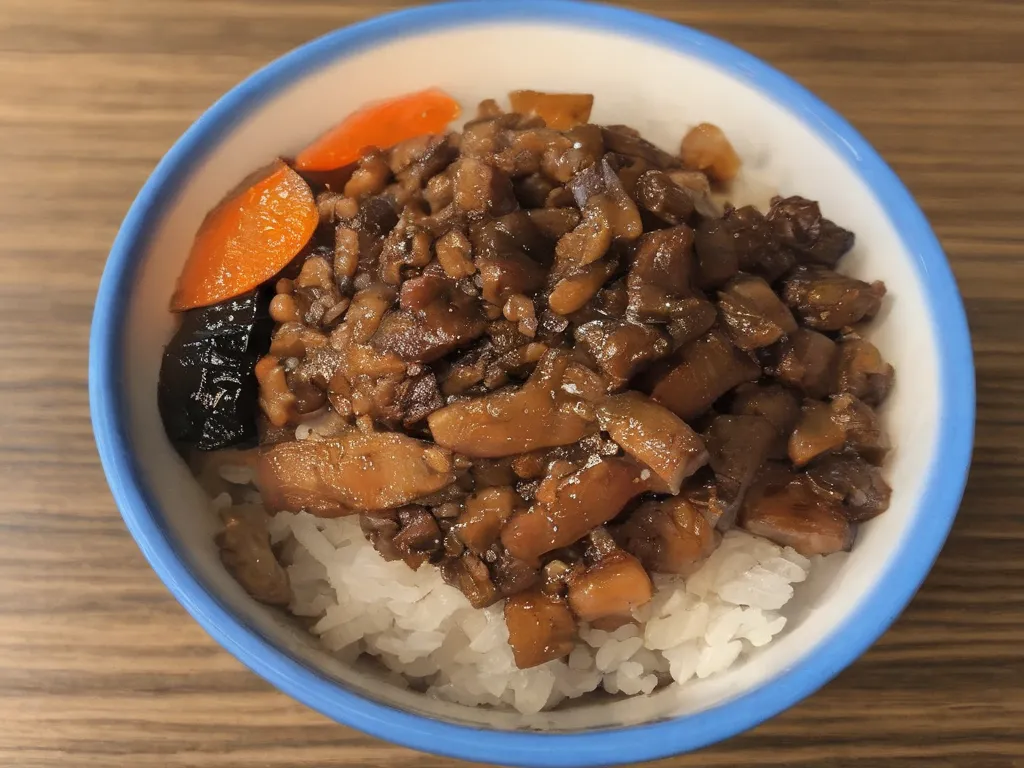 The image shows a bowl of braised pork rice (lu rou fan), a popular Taiwanese dish. It consists of white rice topped with braised pork belly, pickled vegetables, and a soy sauce-based sauce. The dish is typically served with a side of